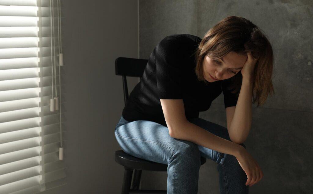 Woman looking down in a private moment of emotional pain.