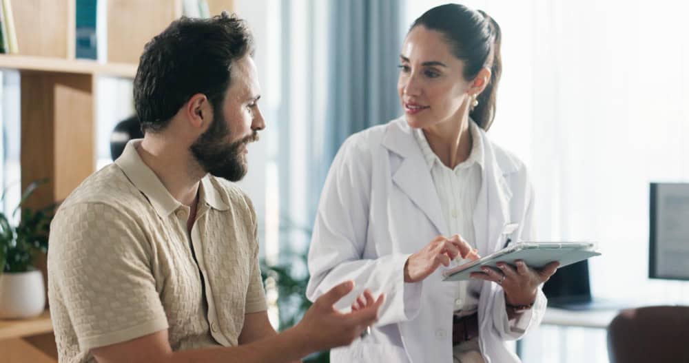 Doctor and patient reviewing health information on a tablet during alcohol addiction treatment in Hanover, MA at Brook Addiction Treatment Center.