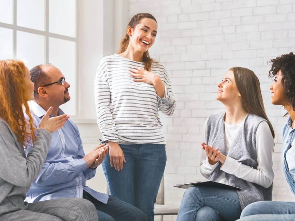 Woman participating in a supportive group meeting at a drug rehab in Hanover, MA.