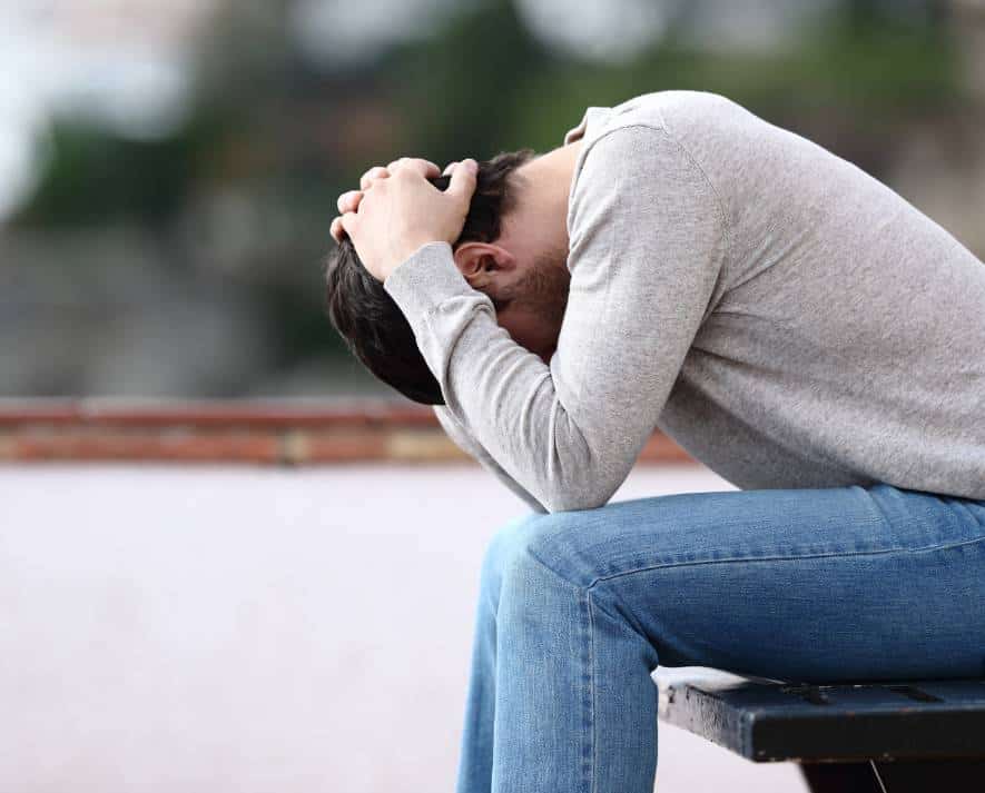 Man sitting with a stressed expression while dealing with MDMA addiction.