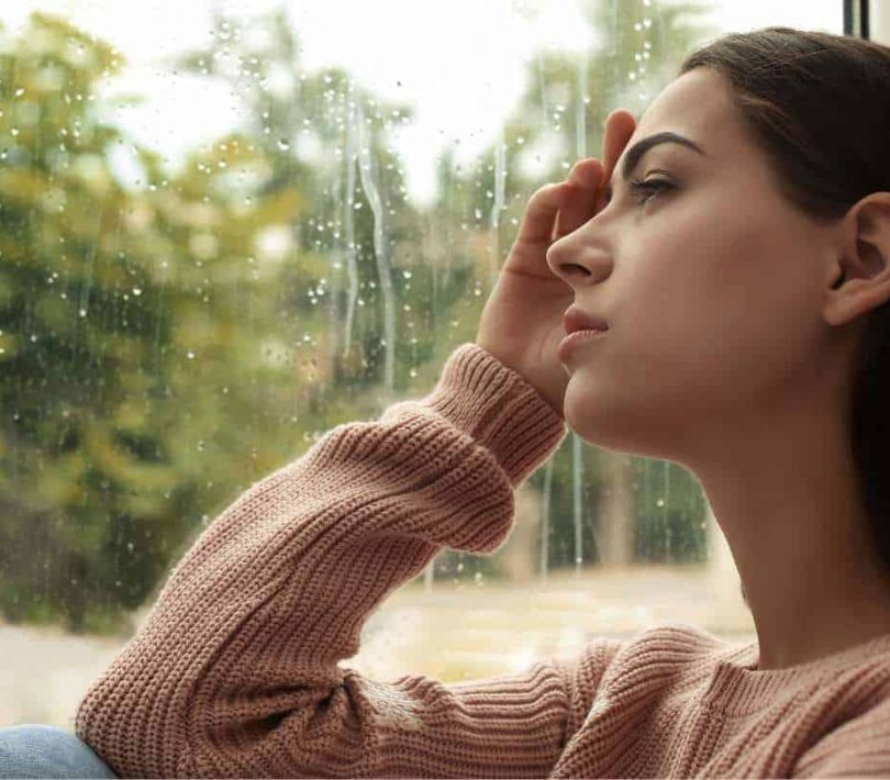 Woman looking out a window during a difficult period of Klonopin addiction.