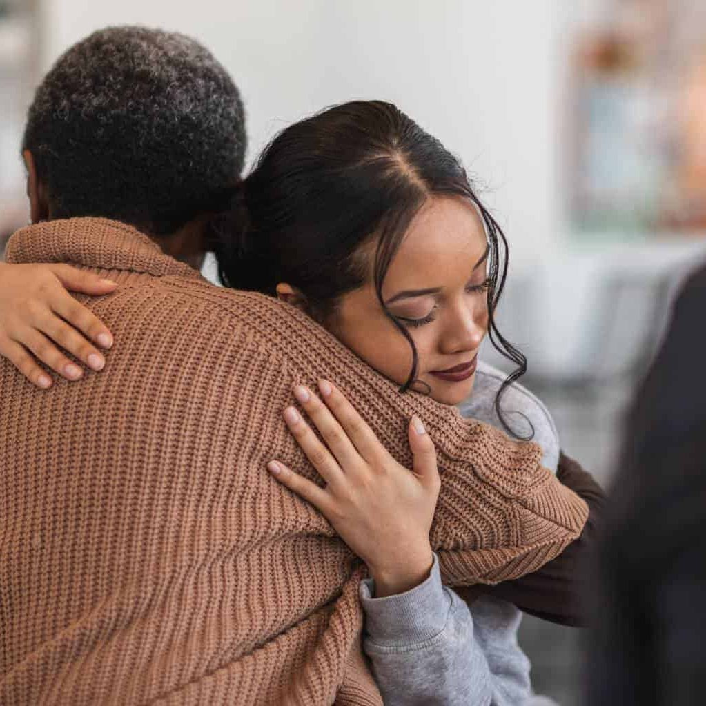 Woman sharing a hug with a loved one during drug addiction treatment in Massachusetts.